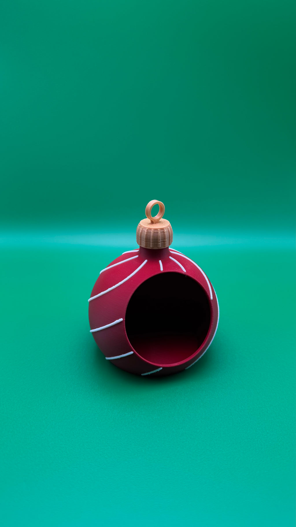 Red Christmas ornament with white stripes on a green background