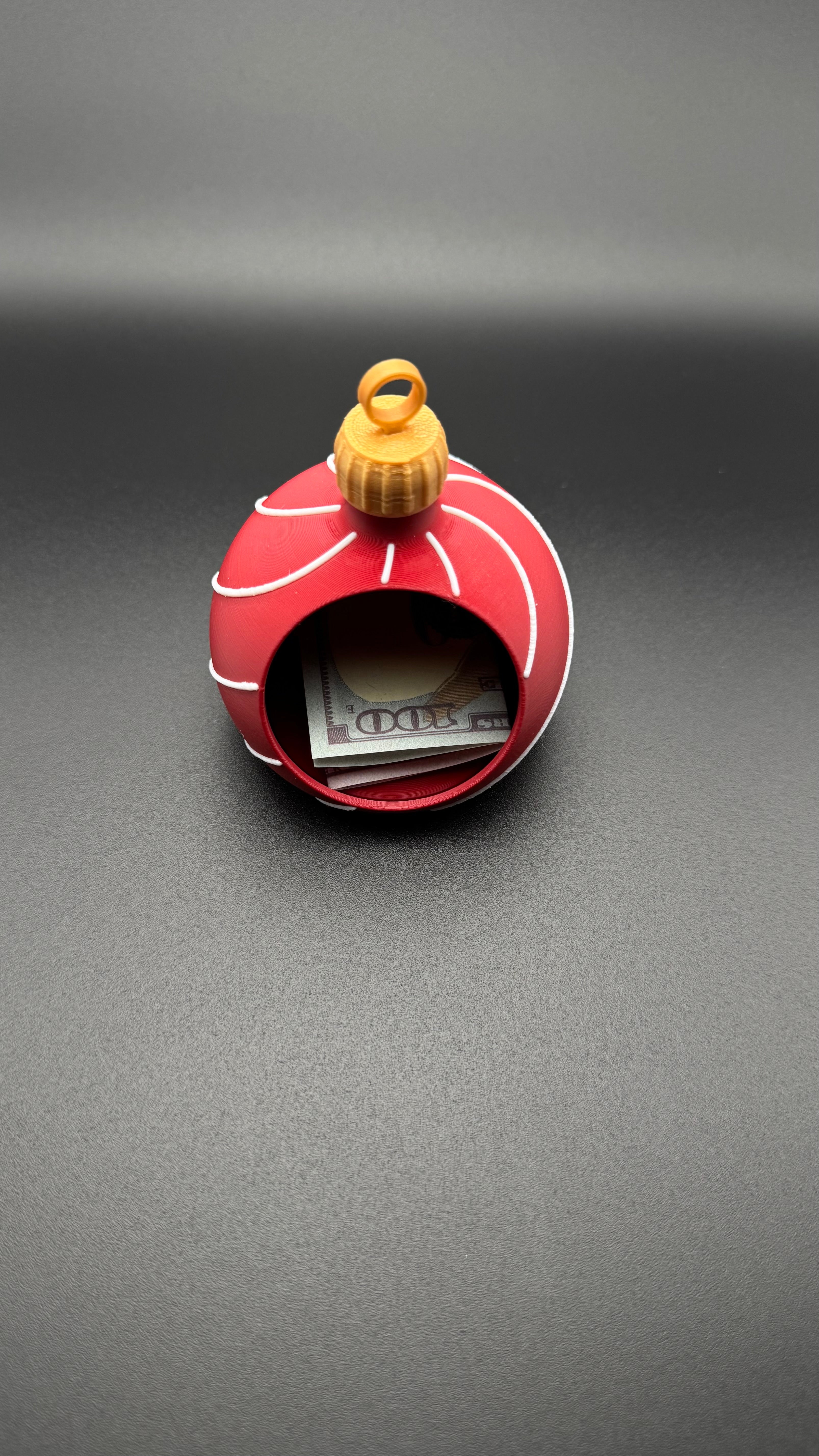 Red and white spherical gift box with money inside